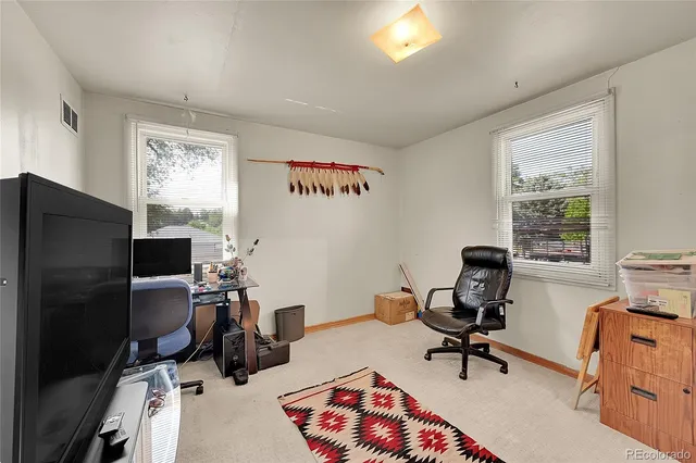 a view of a workspace with furniture and a window