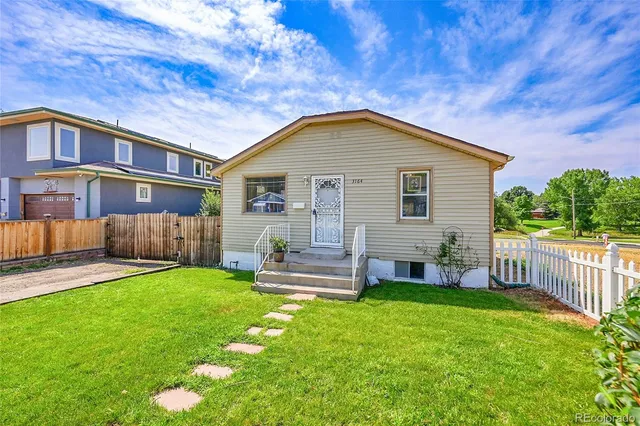 a front view of a house with a yard and trees