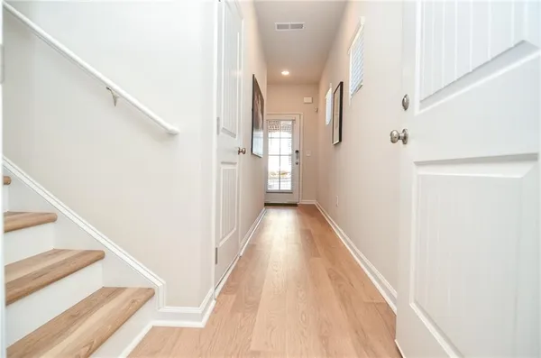 a view of a hallway with white walls and stairs