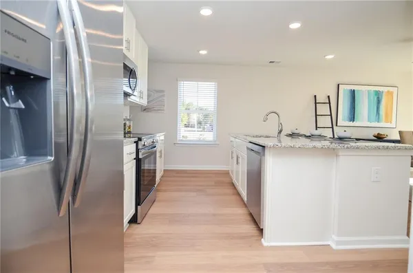 a kitchen with stainless steel appliances granite countertop a refrigerator and a sink