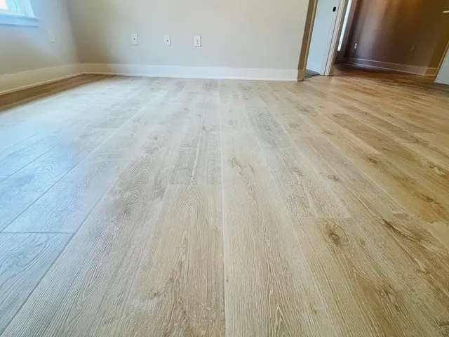 a view of an empty room with wooden floor