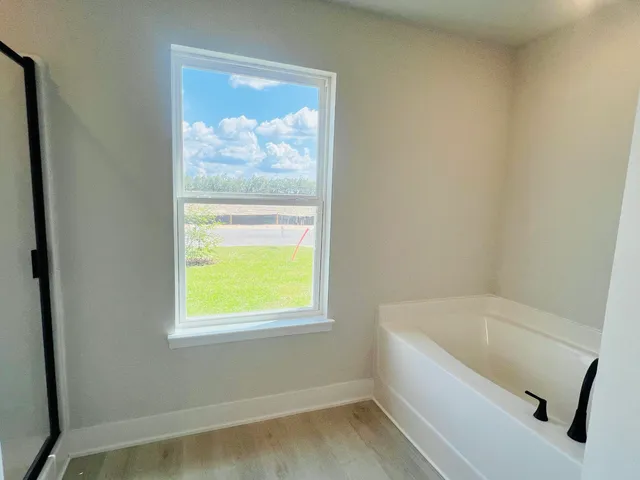 a bathroom with a tub and a window