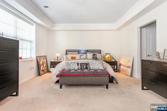 a bedroom with a bed a window and dresser