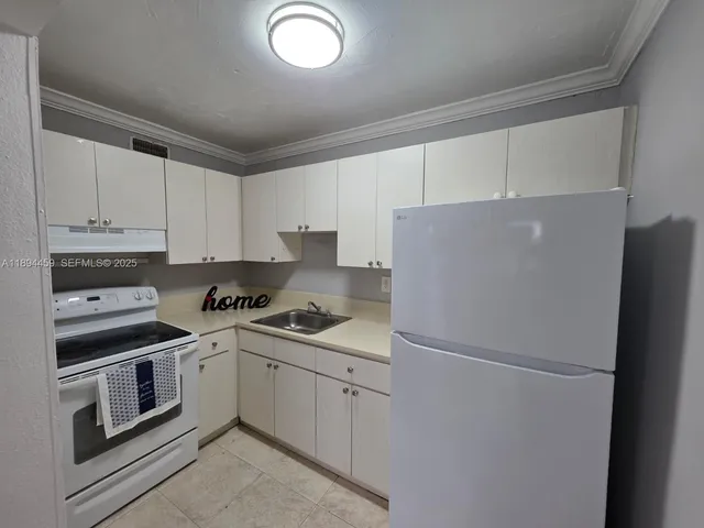a kitchen with a white cabinets and refrigerator