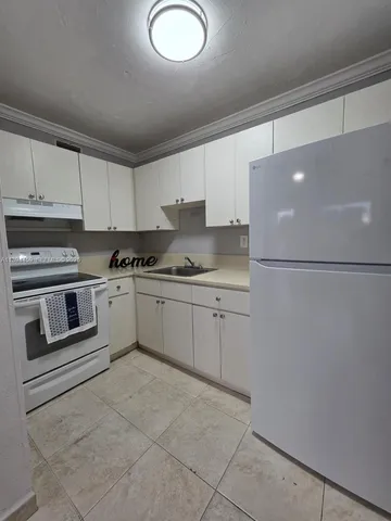 a kitchen with cabinets and white appliances