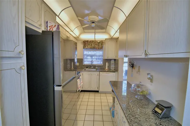 a room with stainless steel appliances granite countertop a refrigerator and cabinets