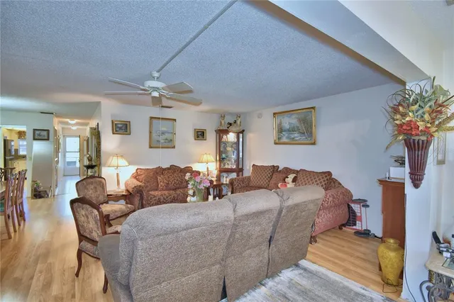 a living room with furniture and a flat screen tv with wooden floor