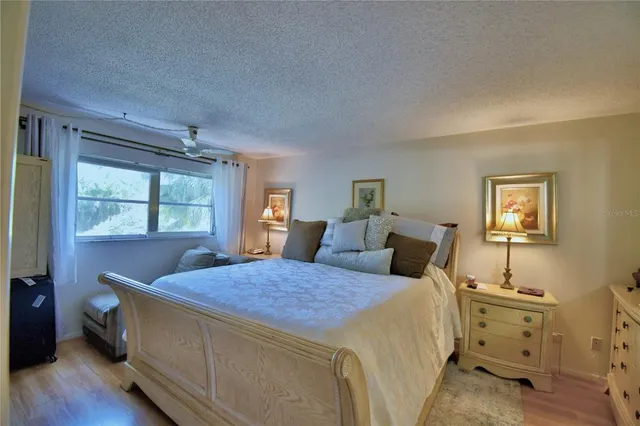 a bedroom with a bed and a flat tv screen on dresser