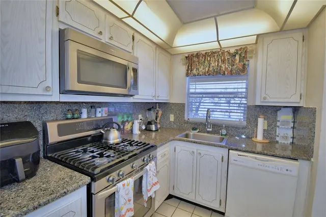 a kitchen with stainless steel appliances granite countertop a stove and a refrigerator