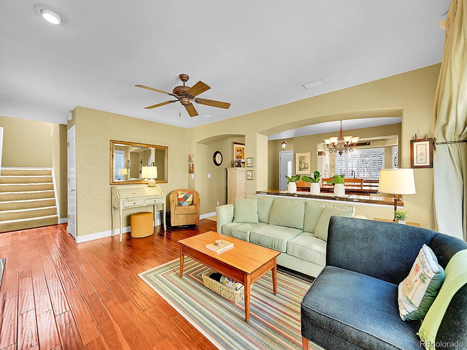 1221 Braewood Avenue Highlands Ranch, CO 80129 - Photo 12 of 45 a living room with furniture and a dining table with wooden floor