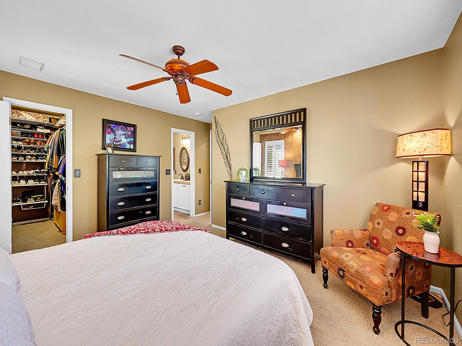 1221 Braewood Avenue Highlands Ranch, CO 80129 - Photo 17 of 45 a bedroom with a bed and a chandelier