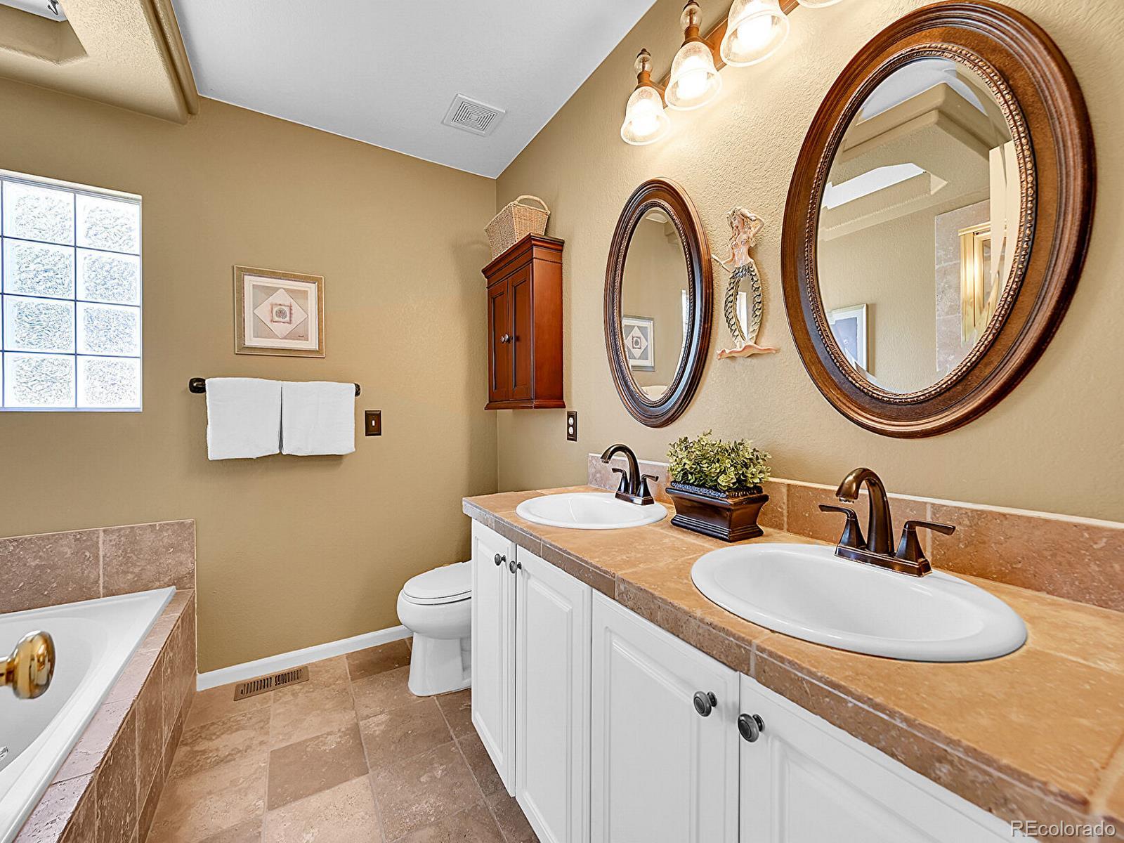 1221 Braewood Avenue Highlands Ranch, CO 80129 - Photo 18 of 45 a bathroom with a toilet a sink and a mirror