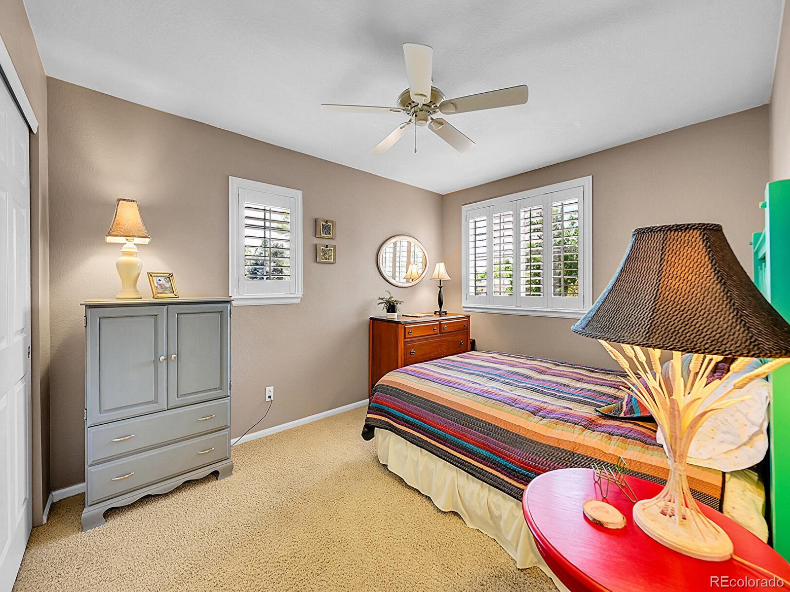1221 Braewood Avenue Highlands Ranch, CO 80129 - Photo 20 of 45 a bedroom with a bed and dresser with mirror