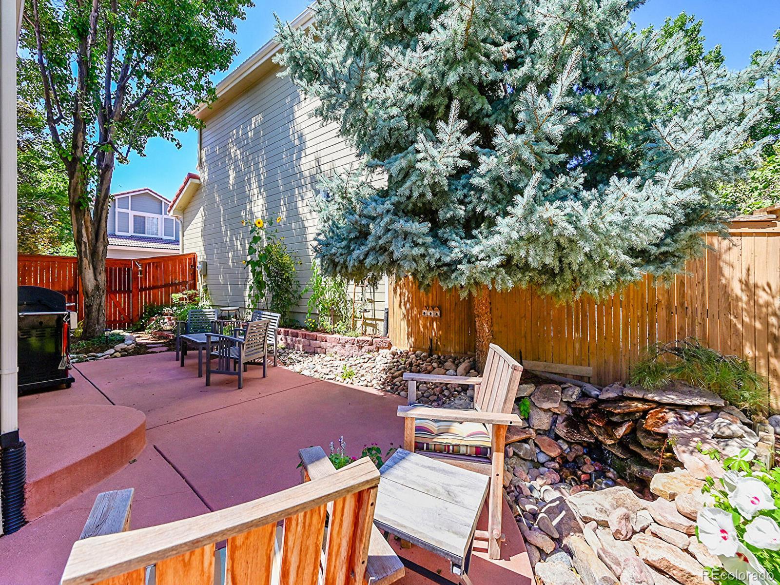 1221 Braewood Avenue Highlands Ranch, CO 80129 - Photo 30 of 45 a view of backyard with outdoor seating and trees