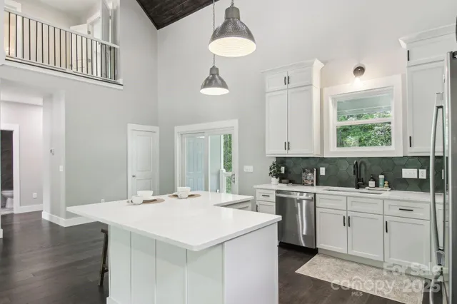 a kitchen with a stove a sink a kitchen island with a stove and white cabinets