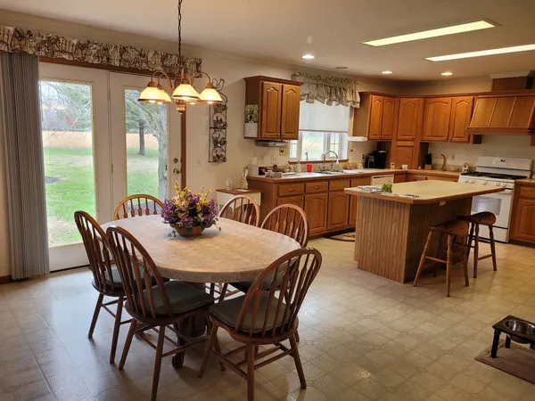 a kitchen with a dining table chairs and refrigerator