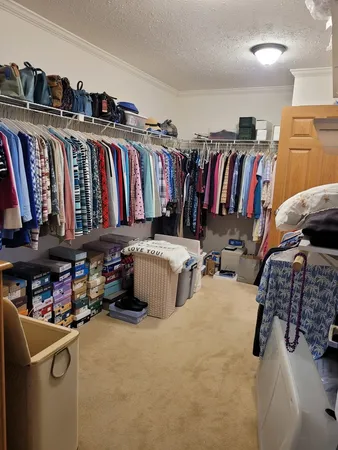 a view of walk in closet with clothes and shoes