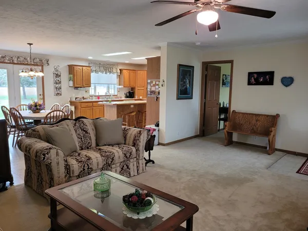 a living room with furniture and a dining table with kitchen view