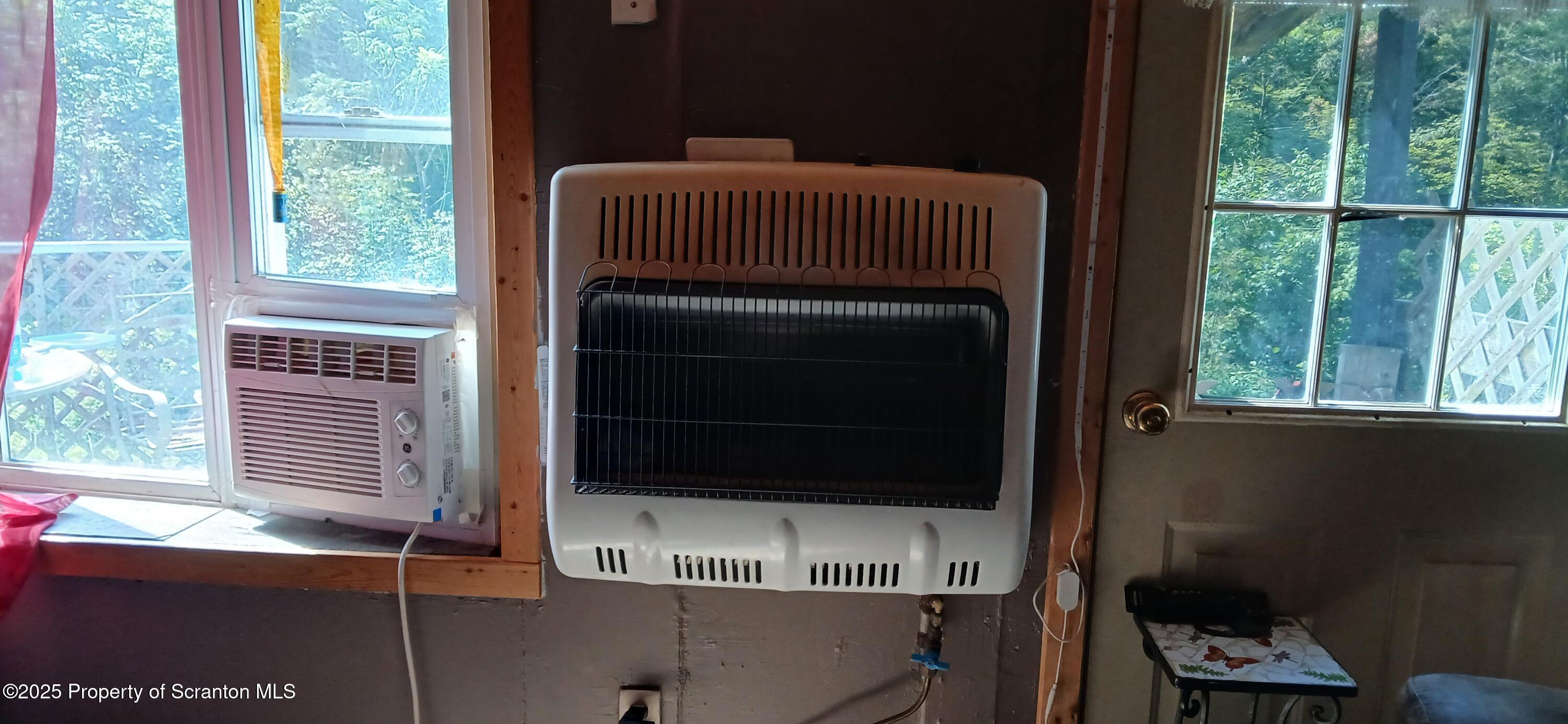 4530 Oak Hill Road Susquehanna, PA 18847 - Photo 15 of 40 a living room with a fireplace and a floor to ceiling window