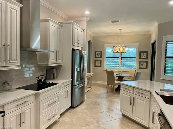 a large white kitchen with a granite countertop sink