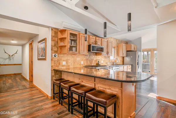 a kitchen with stainless steel appliances kitchen island granite countertop a sink and cabinets