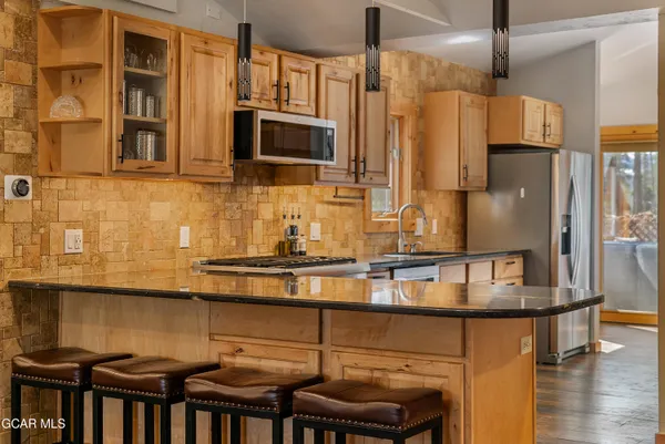 a kitchen with stainless steel appliances granite countertop a stove and a microwave