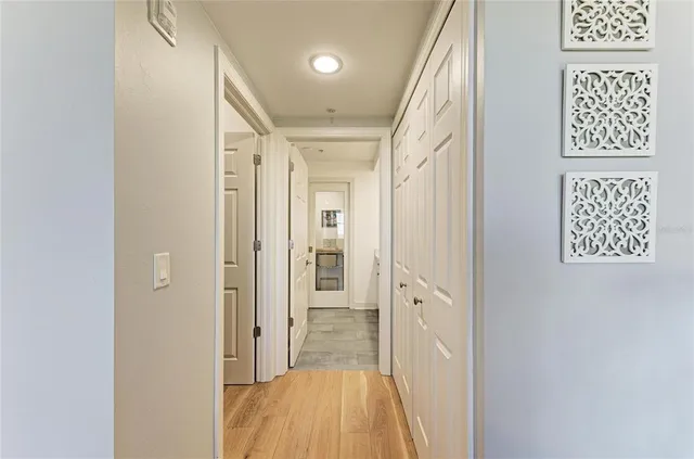 a view of a hallway with wooden floor and closet