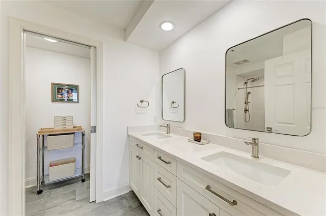 a bathroom with double vanity sinks and a mirror