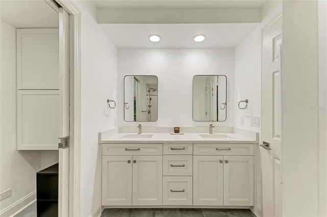 a spacious bathroom with a double vanity sink a mirror and a