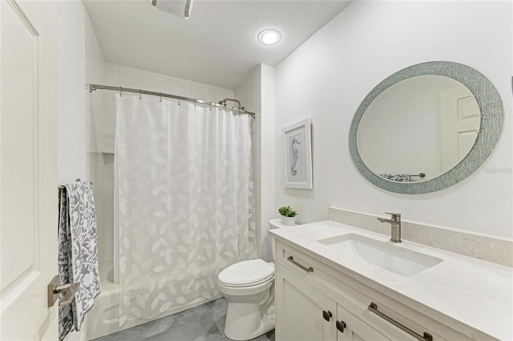 3191 Matecumbe Key Road, Unit 307 Punta Gorda, FL 33955 - Photo 23 of 40 a bathroom with a granite countertop toilet a sink and a mirror