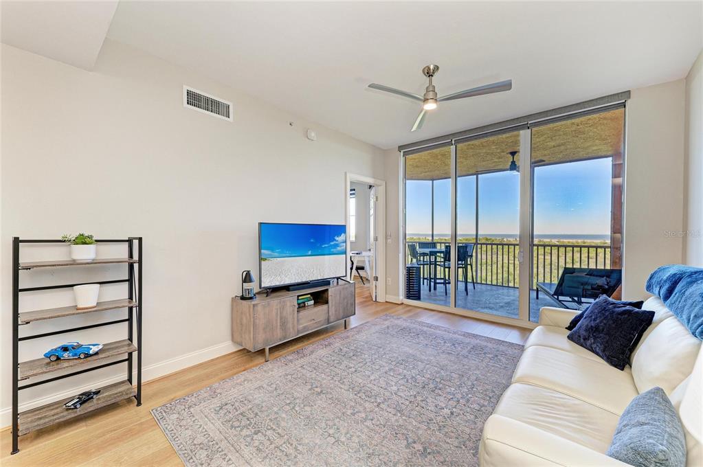 3191 Matecumbe Key Road, Unit 307 Punta Gorda, FL 33955 - Photo 24 of 40 a living room with furniture a flat screen tv and a floor to ceiling window