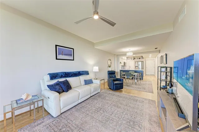a living room with furniture kitchen view and a chandelier