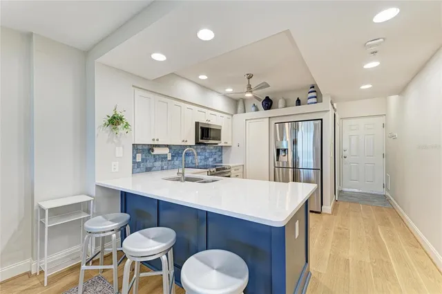 a kitchen with kitchen island a stove a table and chairs in it