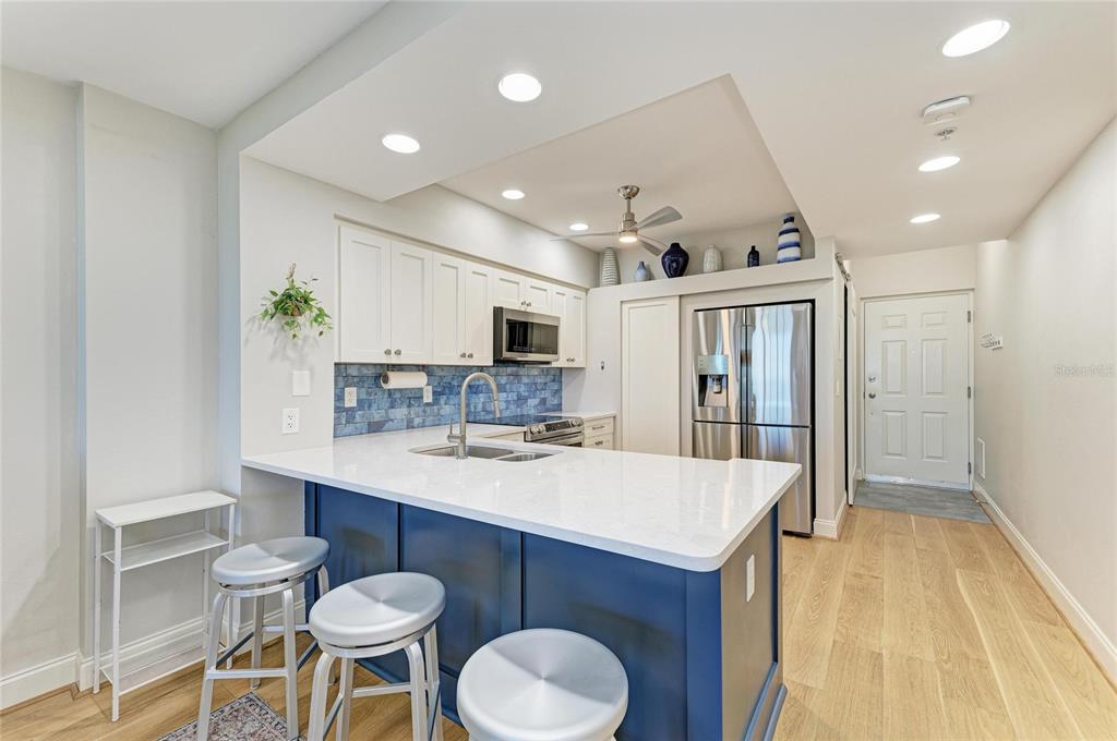 3191 Matecumbe Key Road, Unit 307 Punta Gorda, FL 33955 - Photo 10 of 40 a kitchen with kitchen island a stove a table and chairs in it