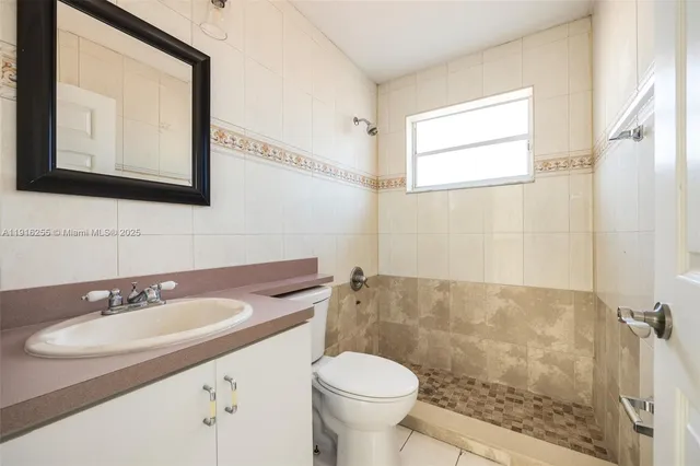 a bathroom with a sink toilet a mirror and shower