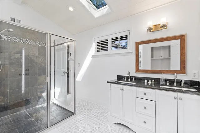 a bathroom with a shower sink and mirror
