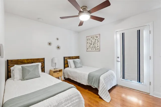 a bedroom with two beds and a ceiling fan