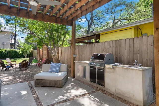 a view of a backyard with table and chairs with a barbeque grill and plants