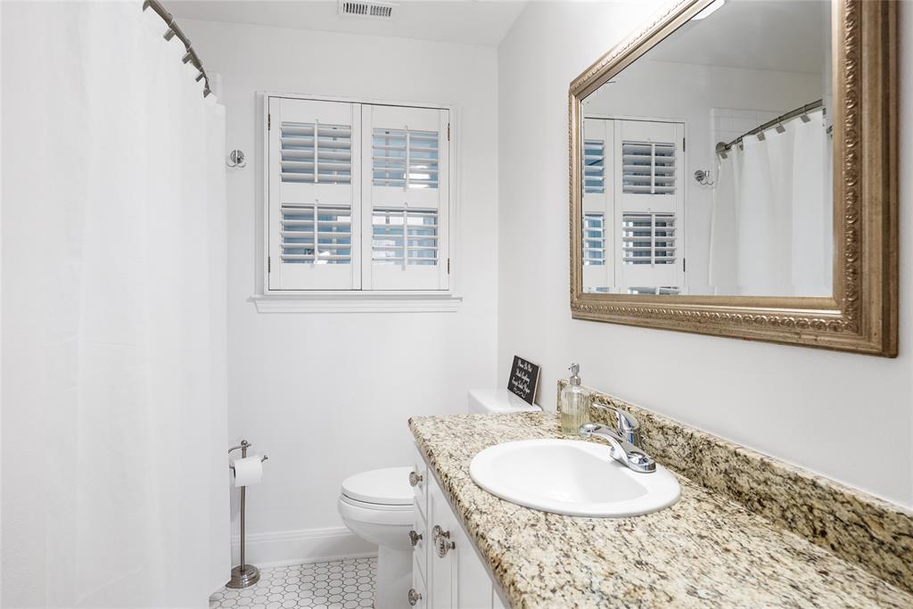 2105 Westover Road Austin, TX 78703 - Photo 18 of 19 a bathroom with a granite countertop sink toilet a mirror and a window