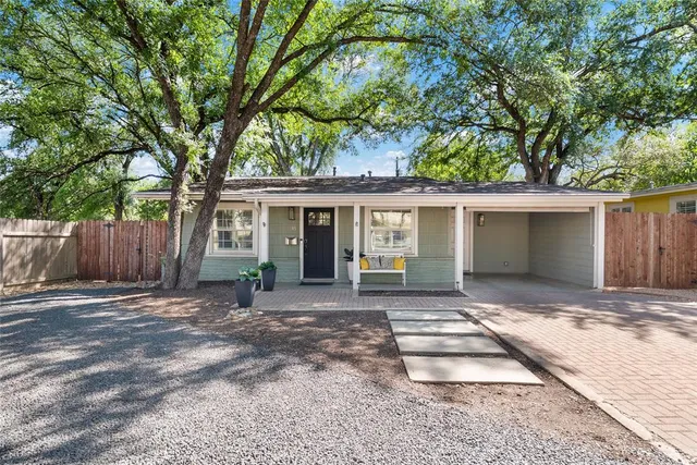 a front view of a house with a garden and yard