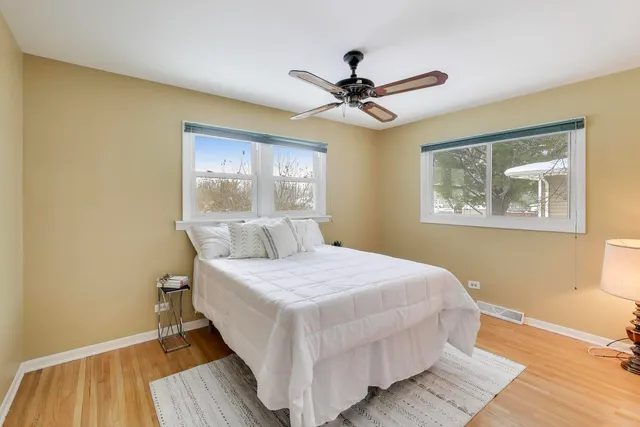 a bedroom with a large bed chandelier and a window
