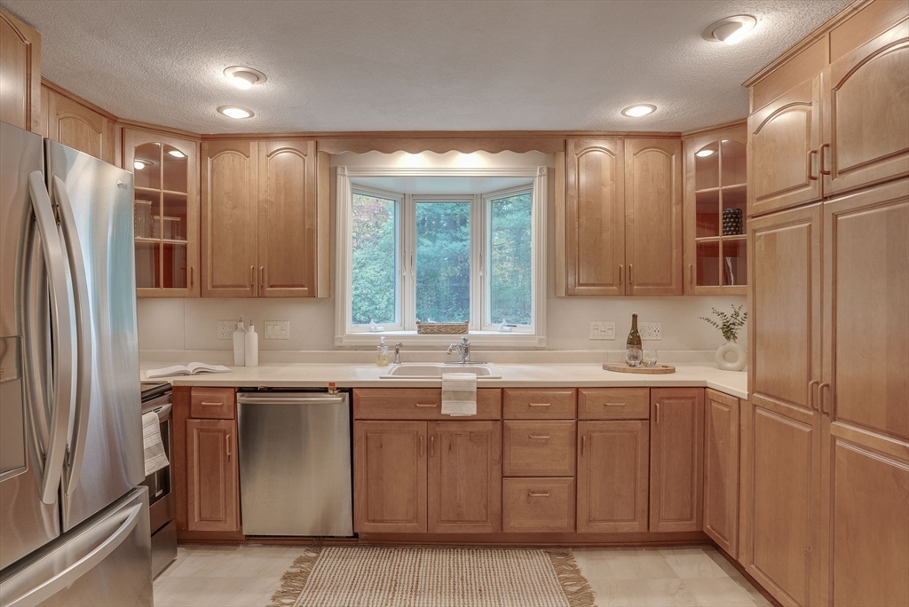 16 Fox Run Road Bedford, MA 01730 - Photo 6 of 37 a kitchen with stainless steel appliances a sink stove and refrigerator