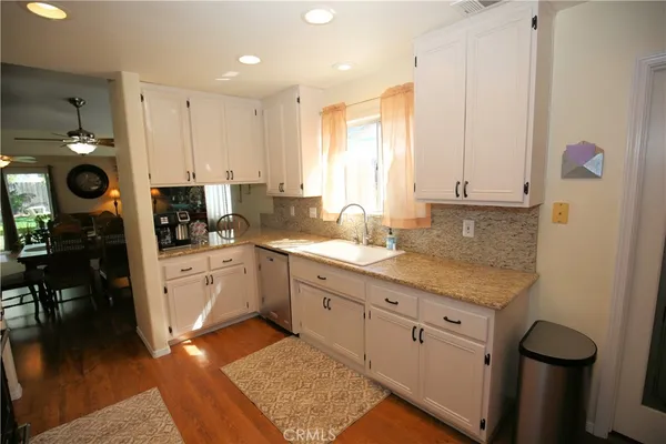 a kitchen with white cabinets and sink