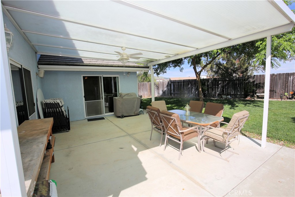 171 Bridgegate Lane Paso Robles, CA 93446 - Photo 27 of 37 a view of a patio with a table and chairs under an umbrella next to a yard
