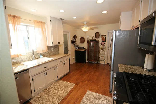 a kitchen with stainless steel appliances granite countertop a refrigerator and a sink