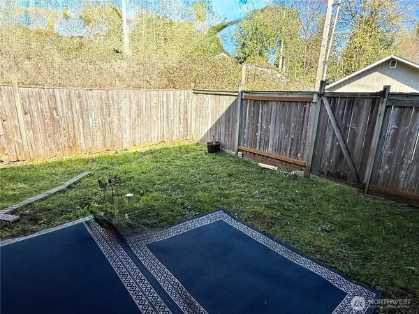 a view of a backyard with wooden fence