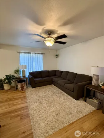 a living room with furniture ceiling fan and a rug
