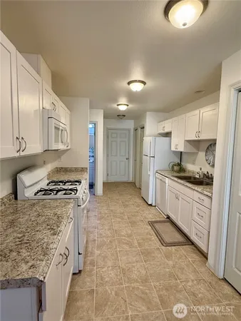 a kitchen with stainless steel appliances granite countertop a stove top oven a sink a counter space and cabinets