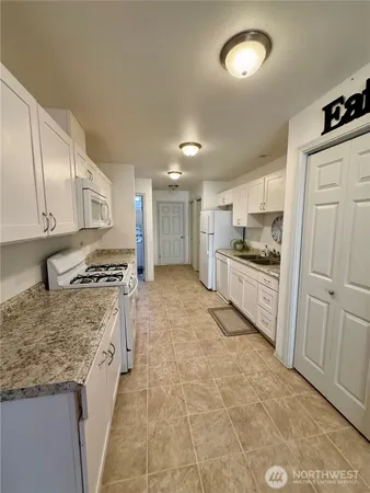a kitchen with stainless steel appliances granite countertop a stove top oven a sink and dishwasher