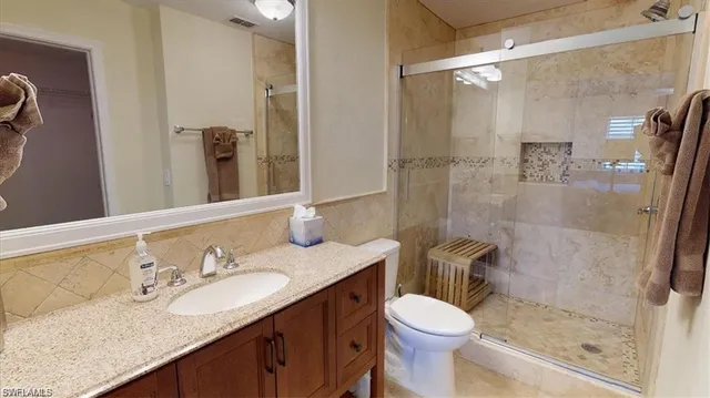 a bathroom with a granite countertop toilet sink and shower